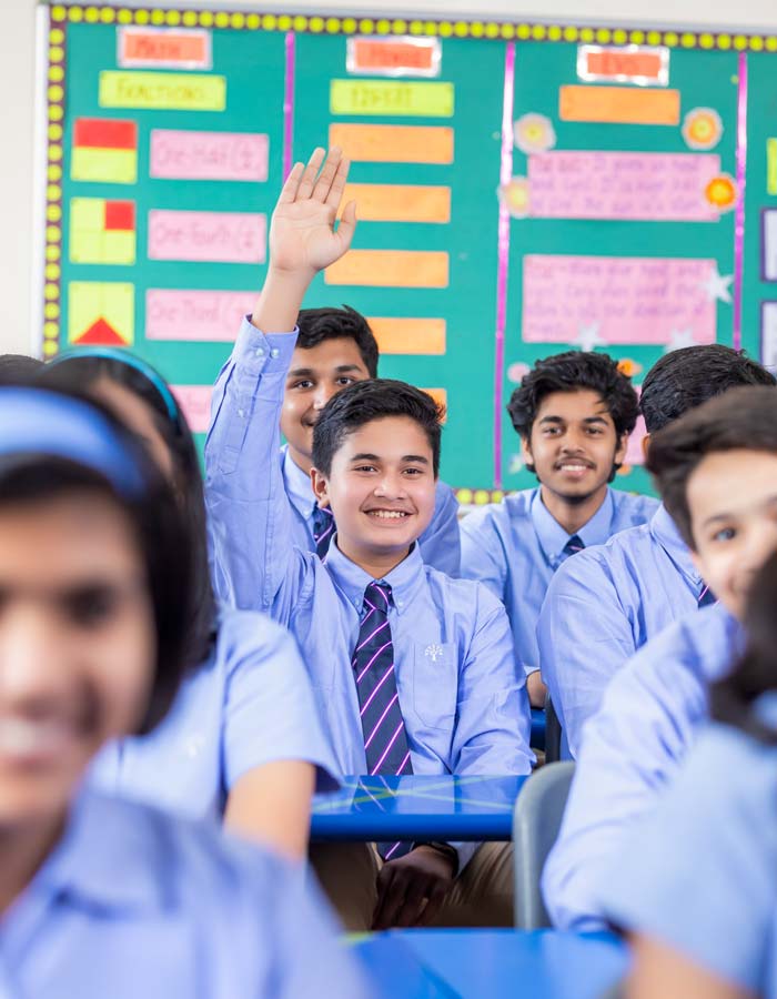 one of the students raising hand in the class room - desktop